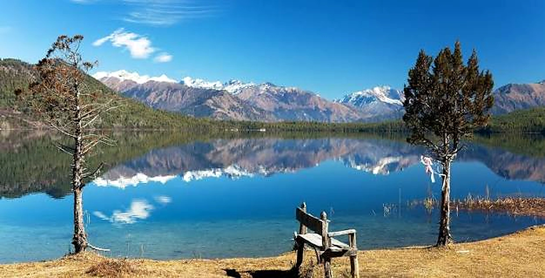 Rara Lake shore with mountain reflections